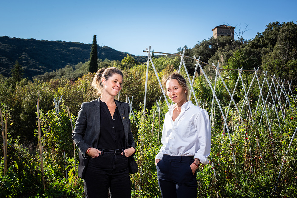 La cheffe Amélie Darvas chemise blanche et la somelière Gaby Benicio en noir dirige le restaurant Äponem (une étoile).Elles posent dans l'un de leurs 5 potagers. A l'arrière plan on distingue une partie de l'ancien presbytère. Vailhan, Hérault